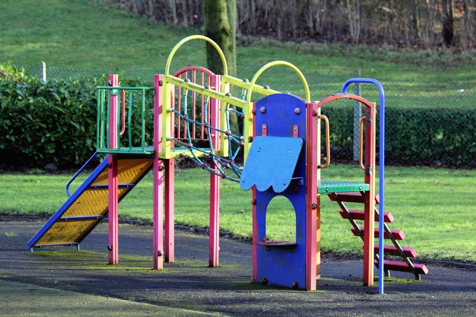 Ryškūs žaidimų aikštelės įrenginiai parke, svarbu saugumui